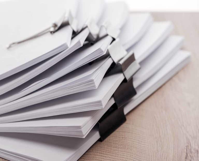 close-up-view-of-stacks-of-blank-paper-with-metal-2022-12-16-18-15-25-utc